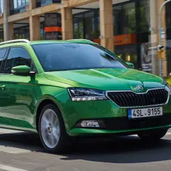 Grön Skoda Fabia kombi kör på stadsgata. Vissa modeller kan ha skoda fabia kamkedja problem.