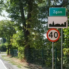 Zielony znak miejscowości Zgoń, obok znak z sylwetką miasta i ograniczenie prędkości do 40 km/h.