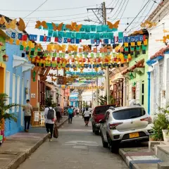 Bunte Häuser und Schmetterlingsgirlanden säumen eine Straße. Perfekt für die beste Reisezeit Curacao, um diese lebendige Atmosphäre zu genießen.