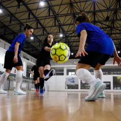 Piłkarki walczą o piłkę na hali. Zastanawiasz się, ile trwa mecz futsalu? To dynamiczna gra!