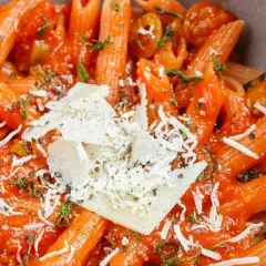 Penne w sosie pomidorowym z parmezanem i ziołami. Ta pyszna potrawka wygląda apetycznie.