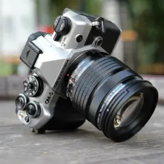 Srebrny aparat OM SYSTEM OM-5 z obiektywem M.ZUIKO DIGITAL 12-45mm 1:4, gotowy do uchwycenia każdej chwili.