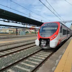 Nowoczesny pociąg Renfe czeka na pasażerów na stacji kolejowej.