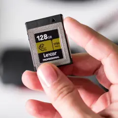 Dłoń trzyma kartę Lexar CFexpress B 128GB, jeden z zaawansowanych rodzajów kart pamięci dla profesjonalistów.