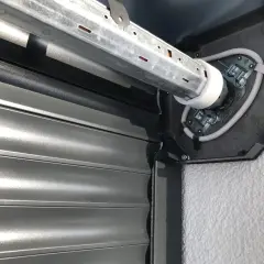 Naprawa żaluzji zewnętrznych: widok mechanizmu silnika i zwiniętego pancerza.