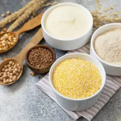 Schalen mit verschiedenen Mehlsorten, darunter Maisgrieß und Kichererbsenmehl, ideal für mehl ohne kohlenhydrate.