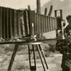 Mężczyzna z aparatami fotograficznymi, które zapoczątkowały historię fotografii. Kto i kiedy wynalazł aparat fotograficzny?