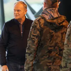 Donald Tusk rozmawia z żołnierzami w mundurach. Czy Donald Tusk był w wojsku? Nie ma informacji, by służył w armii.