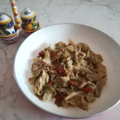 Insalata iceberg cotta in padella con pomodori secchi. Un piatto semplice e gustoso.