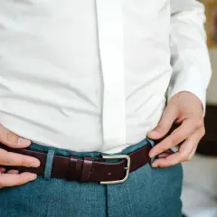 Mężczyzna zapina brązowy pasek. Pasek 100 cm jaki to rozmiar? To idealny rozmiar dla niego.
