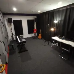 Studio nagraniowe z pianinem, gitarą i mikrofonami. Akustyka pomieszczenia, gdzie może pojawić się jitter, jest poprawiona przez specjalne panele na ścianach.