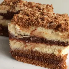 Warstwowe ciasta bez pieczenia z mascarpone, przełożone kremem czekoladowym i posypane kruszonką. Idealne na deser.