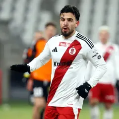 Piłkarz Stali Mielec w białej koszulce z czerwonym pasem, gotowy do gry przeciwko ŁKS Łódź.