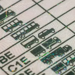 Fragment prawa jazdy z kategoriami pojazdów, symbolizujący możliwość uzyskania prawo jazdy bezterminowe. Widoczne ikony samochodów, autobusów i ciężarówek.