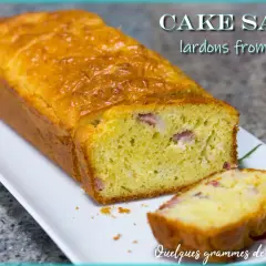 Un cake salé aux lardons et fromage, doré et moelleux, avec une tranche coupée pour révéler les morceaux savoureux.