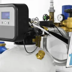 Système de traitement d'eau moderne, affichant sa puissance adoucisseur d'eau. Tuyauterie, vannes et écran digital visibles.
