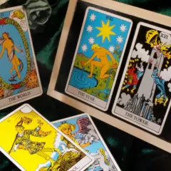 Tarot tak nie: karty Świat, Gwiazda i Wieża. Rozłożenie na aksamitnym tle, obok bukiet róż.