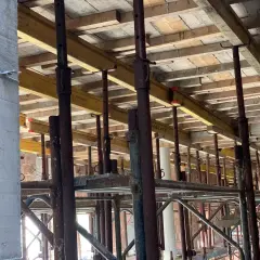 Szalowanie stropu na budowie, z widocznymi drewnianymi belkami i podporami, przygotowane do wylania betonu.