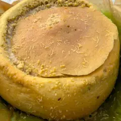 Formaggio casu marzu, con la sua crosta dorata e il ripieno cremoso, pronto per essere gustato.