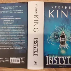 Okładka książki "Instytut" Stephena Kinga. Mroczna grafika z łódką na wodzie i tajemniczą wieżą w tle.