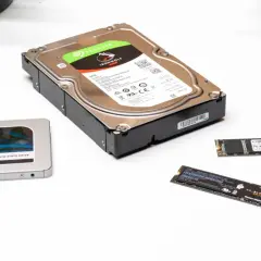 Eine 2,5-Zoll-SSD, eine 6TB-Festplatte und zwei M.2 SSDs liegen nebeneinander.