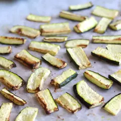 Skivor av zucchini i ugn, lätt gyllene och kryddade, redo att serveras.