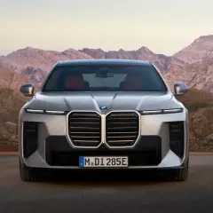 Przód luksusowego BMW 7 2025 z charakterystycznym grillem i nowoczesnymi światłami, zaparkowany na tle surowych górskich krajobrazów.