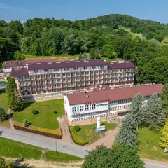 Sanatorium Górnik w Iwoniczu Zdroju, otoczone zielenią, zaprasza na wypoczynek.
