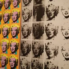 Wielokrotne portrety Marilyn Monroe w stylu serigrafia pop art, w jaskrawych kolorach i czarno-białych wersjach, tworzą ikoniczną kompozycję.