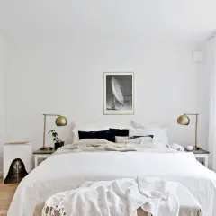Ett ljust och luftigt sovrum med stor säng, konst och växter. En känsla av lugn och harmoni som passar bra för feng shui sovrum.