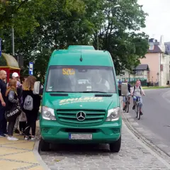 Międzyzdroje busy do Dziwnowa czekają na pasażerów przy przystanku. Zielony bus Emilbus.