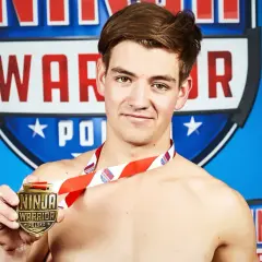 Jan Tatarowicz, zwycięzca Ninja Warrior Polska, dumnie prezentuje medal.