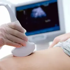 Badanie USG brzucha ciężarnej w 3. trymestrze. Lekarz sprawdza, czy nie występują wodniste upławy.