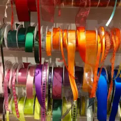 Rouleaux de rubans colorés, de différentes textures et motifs. Ces rubans servent à décorer, emballer, et à ajouter une touche de fantaisie aux vêtements.