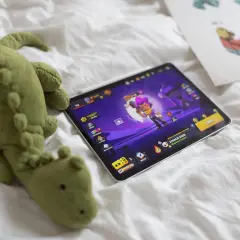 Pluszak-krokodyl obok tabletu z grą Brawl Stars. Zastanawiasz się, brawl stars od ilu lat jest dostępne?