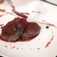 Elegancko podany schab z jelenia, polany sosem z owoców leśnych. Idealny przykład, jak przygotować schab z jelenia na specjalną okazję.
