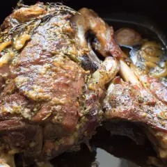 Succulento agnello al forno, dorato e profumato con rosmarino e aglio, pronto per essere gustato.