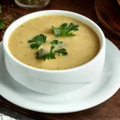 Aksamitna zupa na wielkanoc, udekorowana świeżą natką pietruszki, czeka na świątecznym stole.