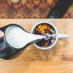 Mleko wlewane do kawy. Zastanawiasz się, jak zasnąć po kawie? Może to pomoże?