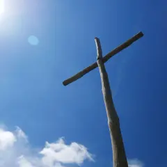 Drewniany krzyż na tle błękitnego nieba. Czy prawosławie to chrześcijaństwo? Symbol wiary.