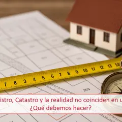 Plano de una finca registral con cinta métrica, brújula y maqueta de casa.
