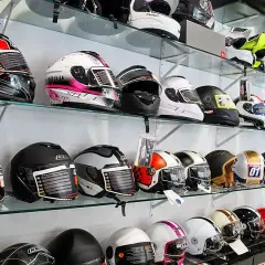 Estanterías llenas de cascos de moto de diversos colores y diseños. ¿Desde cuándo es obligatorio el casco en moto?