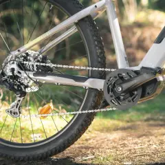 Zbliżenie na tylne koło roweru elektrycznego i mechanizm korbowy. Widać zębatkę, łańcuch i przerzutkę. Długość korby jest kluczowa dla komfortu jazdy.