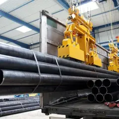Żółte suwnice podnoszą stalowe rury w hali produkcyjnej. Budowa suwnicy jest kluczowa dla sprawnego transportu materiałów.