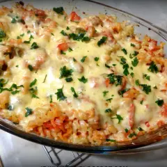 Pyszna zapiekanka makaronowa z warzywami, polana ciągnącym się serem i posypana natką pietruszki. Idealna na obiad!