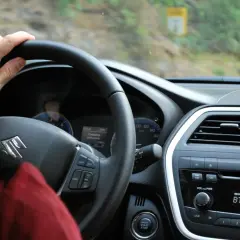 Ręka na kierownicy Suzuki. Rozpoczynają się formalności związane z kupnem używanego samochodu, czas na jazdę próbną.