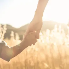 Un niño y un adulto se toman de la mano al atardecer. Pensamientos de orgullosa frases cortas para un hijo varon.