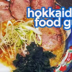 A steaming bowl of ramen, a quintessential Hokkaido food, features tender chashu pork, green onions, and seaweed in a rich broth.