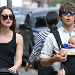 Keira Knightley z mężem i ich maleńkim dzieckiem w nosidełku, spacerując po ulicy.