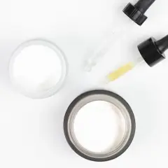 Dwa słoiczki kremu i pipetki z serum, jedno z nich zawiera kwas salicylowy.